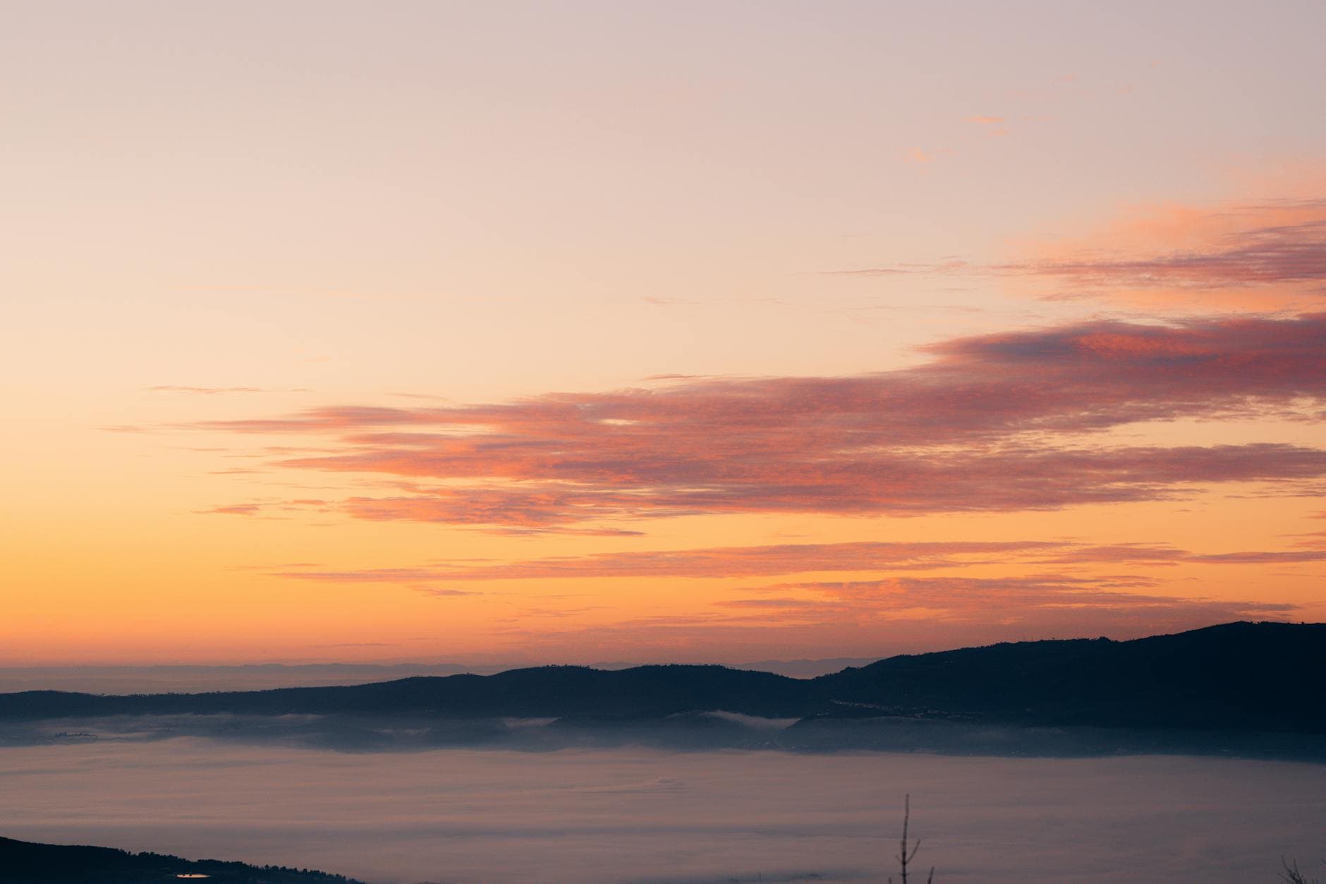 Stunning view of a sunrise over misty mountains with vibrant sky colors.